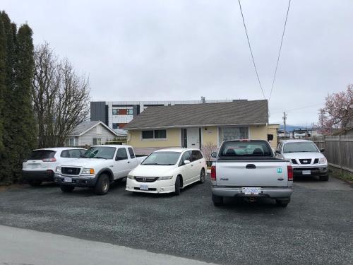 eine Gruppe von Autos, die auf einem Parkplatz geparkt sind in der Unterkunft Shady Willow Guest House -Coach house & Privet Small Compact Rooms with separate entrance in Chilliwack
