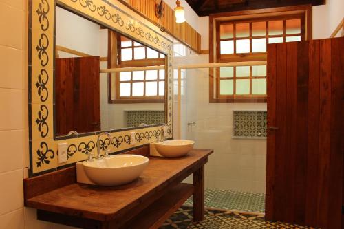 a bathroom with two sinks and a large mirror at Fazenda Capuava in Bananal