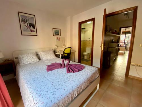 埃爾梅達諾的住宿－Bedroom Medanomar 1，一间卧室配有一张带粉红色浴袍的床