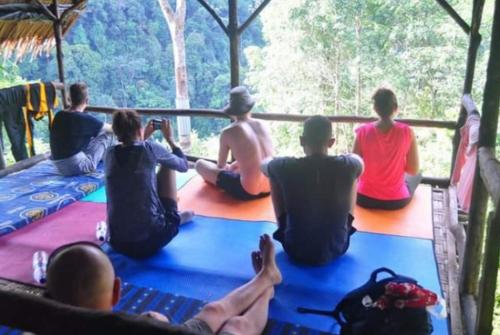 a group of people sitting on the floor of a bus at ORANGUTAN TREKKING LODGE Jungle Tour Only Book with Us in Bukit Lawang