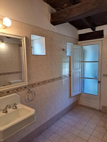 baño con lavabo, espejo y ventana en Casona de coria en Luján de Cuyo