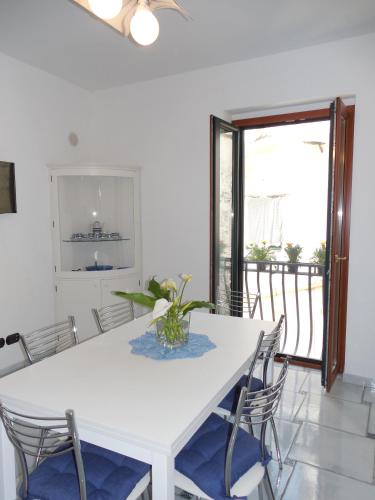 a white dining room with a white table and chairs at Da Zia Pina in Minori