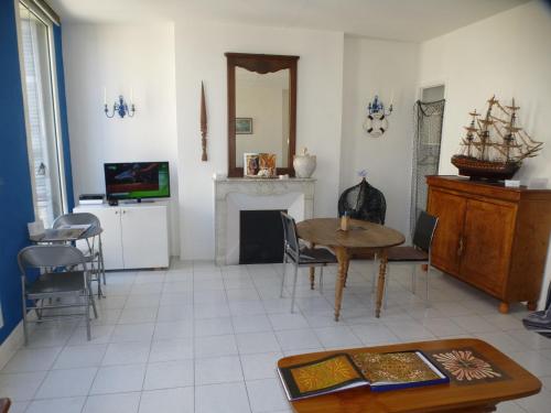un salon avec une table et une cheminée dans l'établissement Vieux Port Appartement Maritime de 72m² et balcon, à Marseille