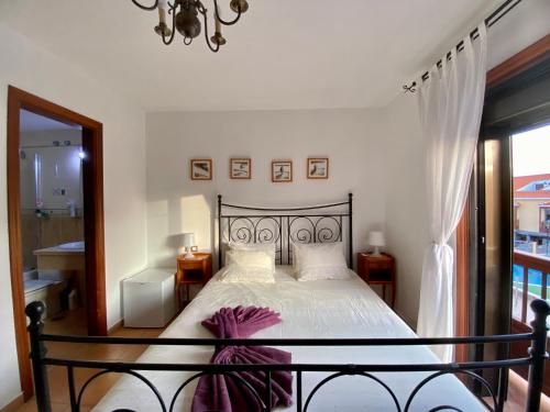 a bedroom with a bed with white sheets and a window at Bedroom Medanomar 2 in El Médano