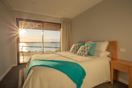 een slaapkamer met een bed en uitzicht op de oceaan bij Beautiful Balmoral Hill Apartment in Christchurch