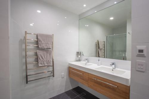 a bathroom with a sink and a mirror at Beautiful Balmoral Hill Apartment in Christchurch