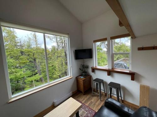 a living room with two chairs and two windows at Brown's Beach Guest Suite in Ucluelet