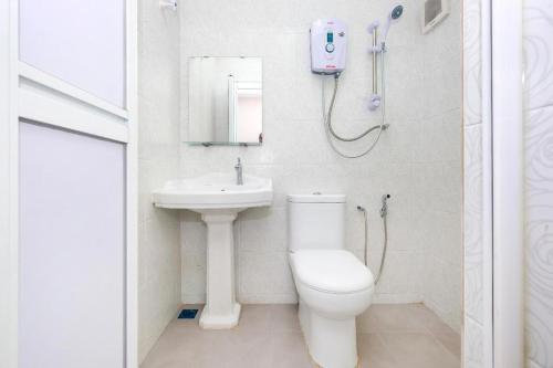 La salle de bains est pourvue de toilettes, d'un lavabo et d'une douche. dans l'établissement Ar Rayyan Hotel, à Tanah Rata