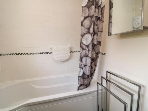 a bathroom with a tub and a shower at 3 Rosecraddoc Lodge in Saint Cleer