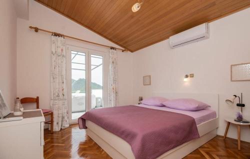 um quarto com uma cama com lençóis roxos e uma janela em Apartment Green Peace em Zadvarje