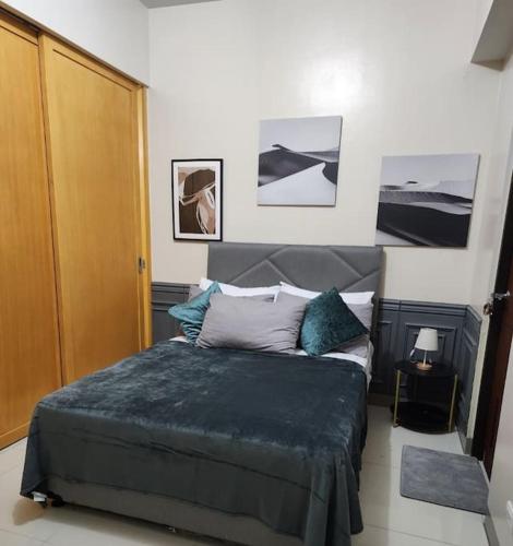 a bedroom with a large bed in a room at Cozy Studio Unit near Uptown Mall BGC in Manila