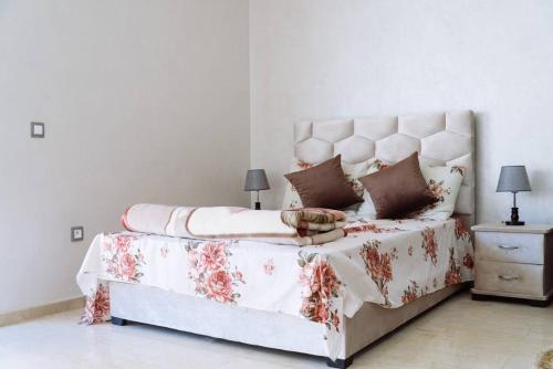 a bedroom with a large bed with a floral blanket at Cozy New Studio in Mohammedia in Mohammedia
