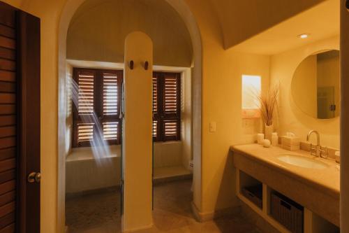 a bathroom with a tub and a sink and a mirror at Cala de Mar Resort & Spa Ixtapa in Ixtapa