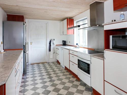 a kitchen with white appliances and a checkered floor at 6 person holiday home in Hadsund-By Traum in Hadsund