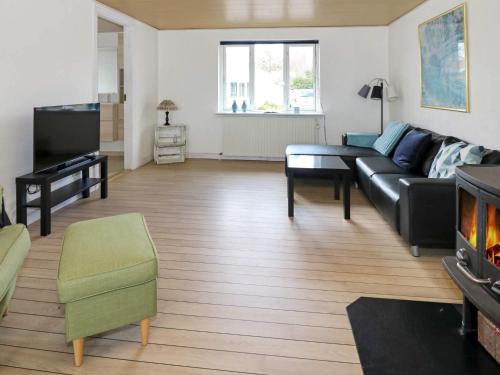 a living room with a couch and a tv at 6 person holiday home in Hadsund-By Traum in Hadsund