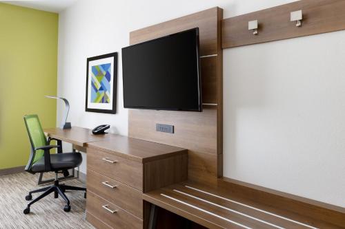 an office with a desk and a tv on a wall at Holiday Inn Express & Suites Oakhurst-Yosemite Park Area by IHG in Oakhurst