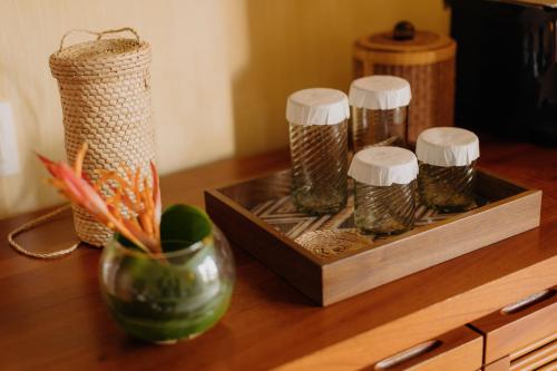 a wooden table with a tray with four jars of spices at Cala de Mar Resort & Spa Ixtapa in Ixtapa
