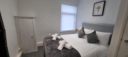 a bedroom with a bed with two teddy bears on it at Warwick St by Prestige Properties SA in Barrow in Furness