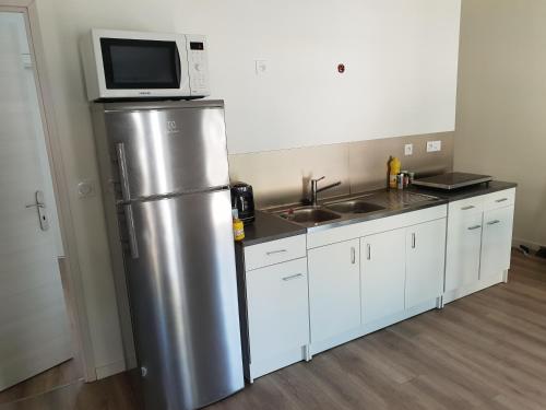 Il comprend une cuisine équipée d'un réfrigérateur et d'un four micro-ondes. dans l'établissement Gite porte de lyon aéroport, à Pont-de-Chéruy