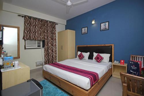 a bedroom with a bed and a blue wall at Flagship 9046 Hotel Metro Star in New Delhi