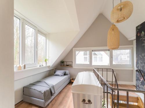 a living room with a couch and windows at Atmospheric holiday home in Noordwijkerhout near the beach in Noordwijkerhout