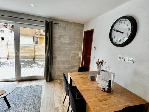 une salle à manger avec une grande horloge sur un mur dans l'établissement Charmant 3 pièces tout confort, 4 à 6 pers, sauna, terrasse, proche pistes et commodités - FR-1-263-526, à Valloire