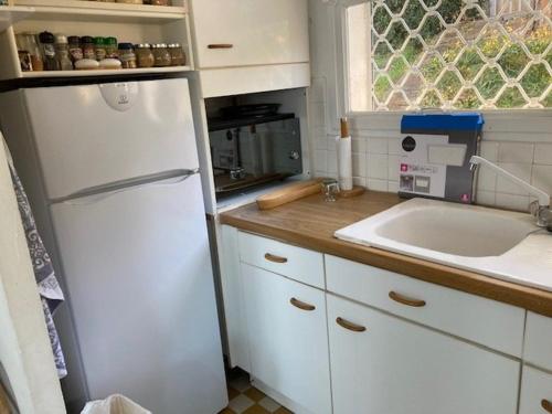 une cuisine avec un réfrigérateur blanc et un évier dans l'établissement Villa au Lavandou avec terrasse, climatisation et option Wi-Fi - FR-1-308-174, au Lavandou
