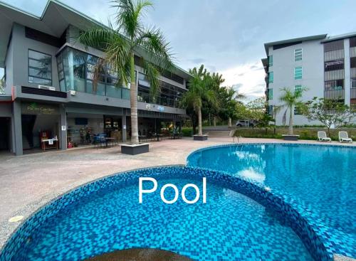 a swimming pool in front of a building at D' Palm Garden Homestay Lahad Datu. in Lahad Datu