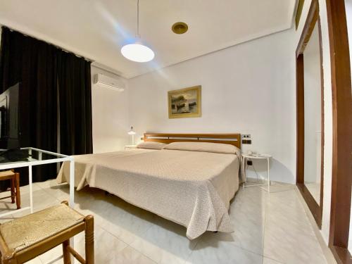 een slaapkamer met een groot bed en een tafel bij Hotel Venta El Puerto in Murcia