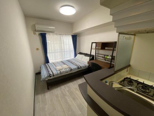 Kleines Zimmer mit einem Bett und einem Waschbecken in der Unterkunft ホワイトテラス桜新町 in Tokio
