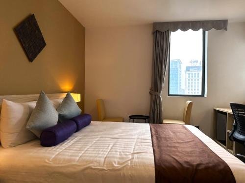 a bedroom with a bed with pillows and a window at Hotel Yah Hanoi & Spa in Hanoi