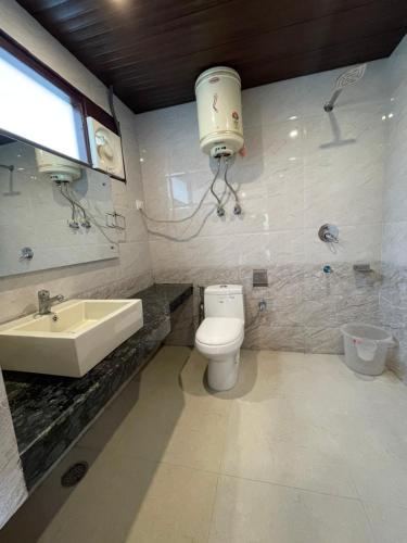 łazienka z toaletą i umywalką w obiekcie The Royal Majestic Mountain View w mieście Manāli