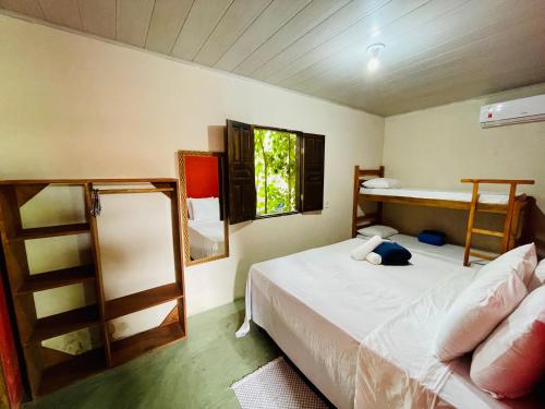 um quarto com 2 beliches e uma janela em Pousada Aquarela em Caraíva