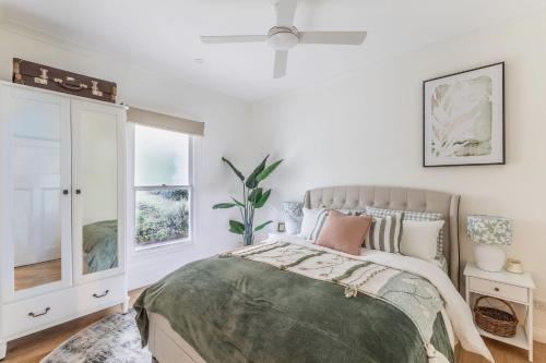 a bedroom with a bed and a window at Myrtle Creek Cottage in Myrtleford