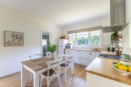 a kitchen with a table and chairs in a kitchen at Myrtle Creek Cottage in Myrtleford