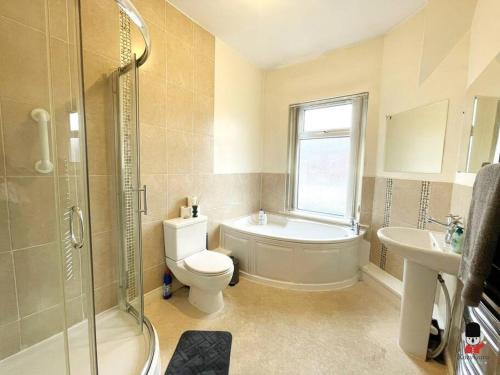a bathroom with a tub and a toilet and a sink at KozyGuru / 2BR 4 Beds / Modern Fully equipped House / Atherton Manchester / Close to Supermarket and Train Station / UMAT144 in Atherton