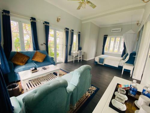 a living room with a couch and a bed at Vườn Vua Resort & Villas in Phú Thọ