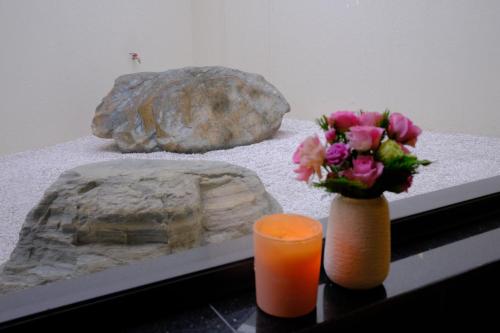 a table with a vase of flowers and a rock at FAMILLE HA NAM in Lưu Xá