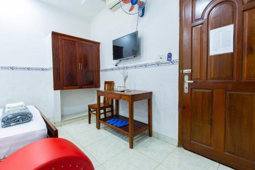 a room with a bed and a desk and a door at Hoa Cúc Phương Hotel Dĩ An - Bình Dương in Dĩ An