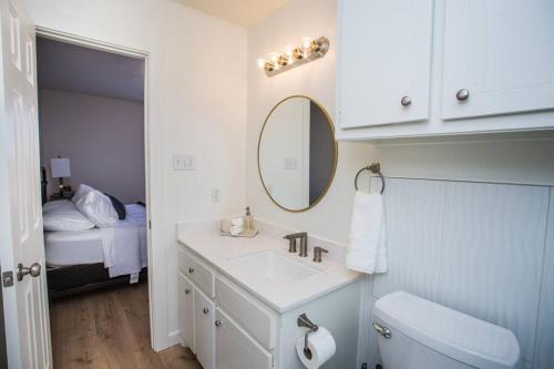 a bathroom with a sink and a mirror and a bed at 7 beds Relax by Texas Tech & Hospitals Sleeps 10 in Lubbock