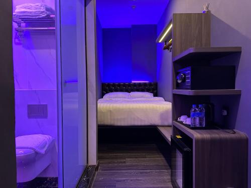 a purple room with a bed and a bathroom at HOTEL JJH - newly opened near BUGIS in Singapore