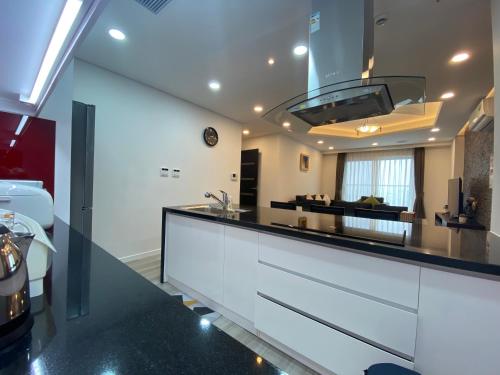 a kitchen with white cabinets and a black counter top at FAMILLE HA NAM in Lưu Xá