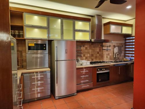 a kitchen with stainless steel appliances and brown cabinets at Mawar Singgah in Putrajaya