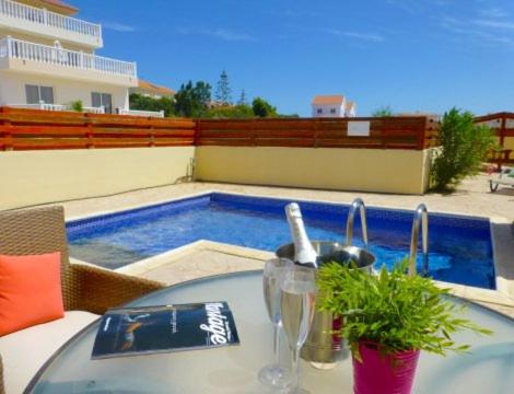 阿依纳帕Nissi Beach Golden Villas的一张桌子、一个水槽和一个游泳池