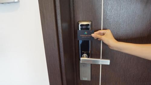 a person unlocking a door with a card on it at FAMILLE HA NAM in Lưu Xá