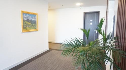 a hallway with a painting on the wall and a plant at FAMILLE HA NAM in Lưu Xá