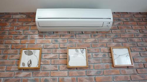a printer on a brick wall with three pictures at FAMILLE HA NAM in Lưu Xá