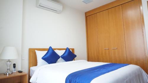 a bedroom with a large bed with blue pillows at FAMILLE HA NAM in Lưu Xá