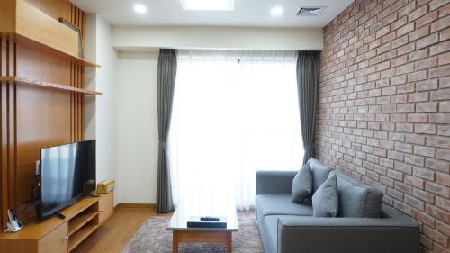 a living room with a couch and a brick wall at FAMILLE HA NAM in Lưu Xá