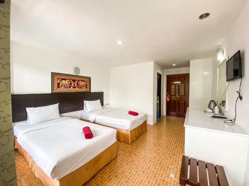 a hotel room with two beds and a television at The Palace Aonang Resort in Ao Nang Beach